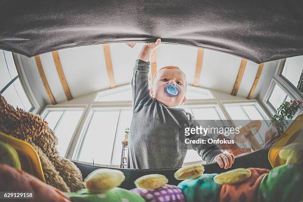 pov baby boy explorando y mirando dentro de la caja de juguete - toy box fotografías e imágenes de stock