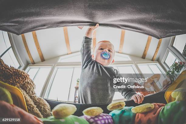 pov baby boy exploring and looking inside toy box - child and unusual angle stockfoto's en -beelden