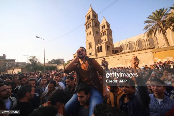 Egyptians shout slogans as they gather outside the the Saint Peter and Saint Paul Coptic Orthodox Church in Cairo's Abbasiya neighbourhood after it...