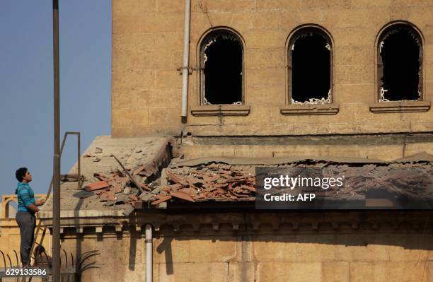 An Egyptian man looks at the damage at the scene of a bomb explosion that targeted the Saint Peter and Saint Paul Coptic Orthodox Church on December...