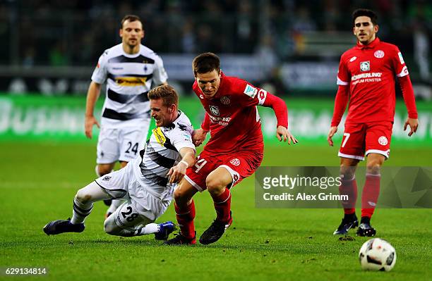 Andre Hahn of Moenchengladbach battles for the ball with Gaetan Bussmann of Mainz during the Bundesliga match between Borussia Moenchengladbach and...