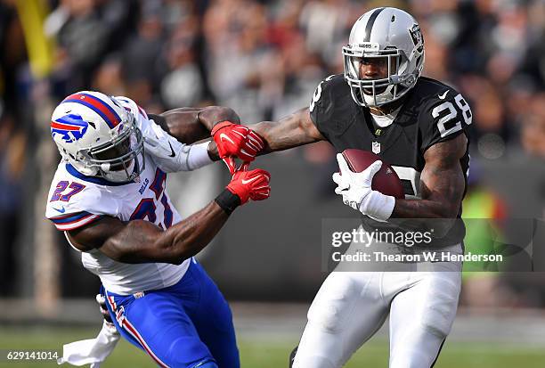 Latavius Murray of the Oakland Raiders fights off would be tackler James Ihedigbo of the Buffalo Bills during their NFL football game at the...