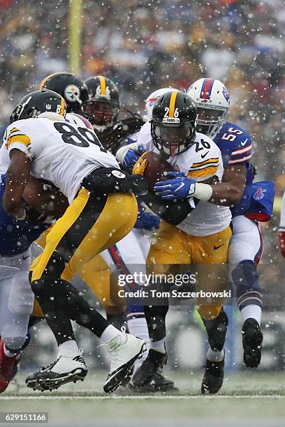 Le'Veon Bell of the Pittsburgh Steelers is brought down by Jerry Hughes of the Buffalo Bills during the first half at New Era Field on December 11,...