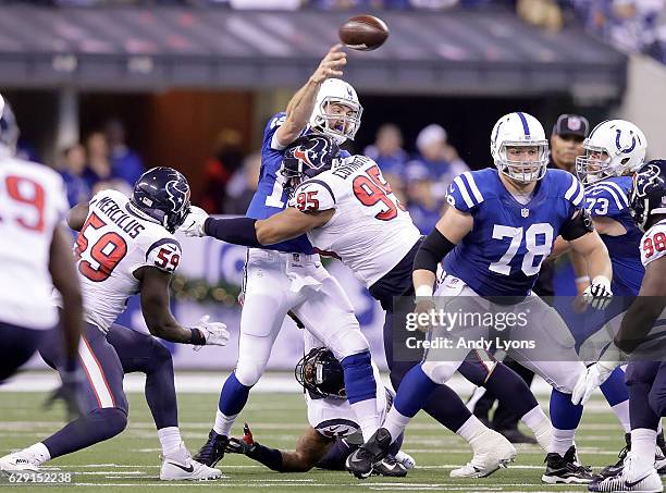 Quarterback Andrew Luck of the Indianapolis Colts is hit by Christian Covington of the Houston Texans during the game at Lucas Oil Stadium on...