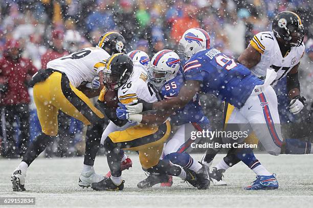 Le'Veon Bell of the Pittsburgh Steelers is tackled by Jerry Hughes of the Buffalo Bills during the first half at New Era Field on December 11, 2016...