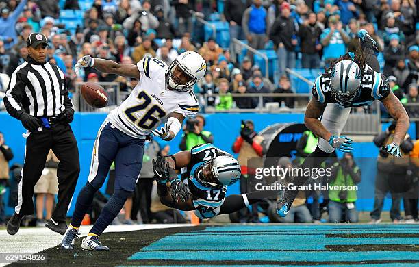 Casey Hayward of the San Diego Chargers lunges for a tipped pass against Devin Funchess and teammate Kelvin Benjamin of the Carolina Panthers in the...