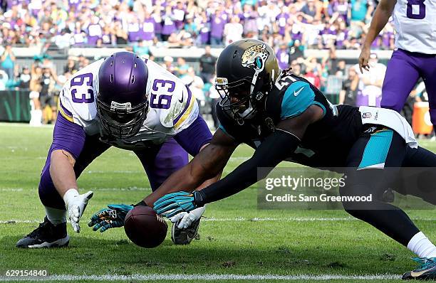 Brandon Fusco of the Minnesota Vikings and Jarrod Wilson of the Jacksonville Jaguars reach for an apparent fumble during the game at EverBank Field...