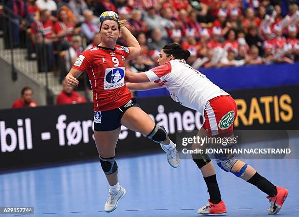 Denmark's Stine Bodholt Nielsen tries to stop Norway's Nora Mork as she prepares to throw the ball during the Women's European Handball Championship...