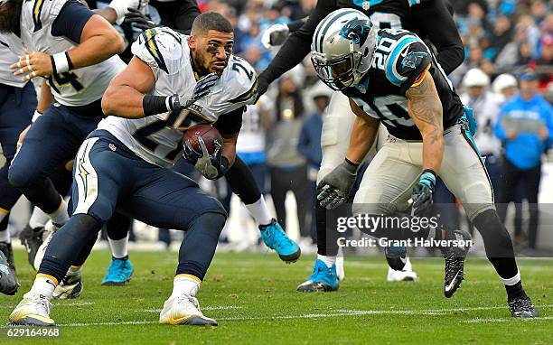 Kenneth Farrow of the San Diego Chargers loses his helmet and keeps running against Kurt Coleman of the Carolina Panthers in the 3rd quarter during...