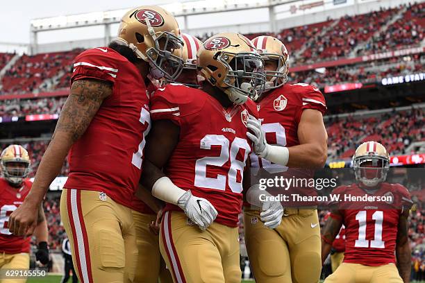 Carlos Hyde of the San Francisco 49ers celebrates with teammates after scoring against the New York Jets in the first quarter of their NFL game at...