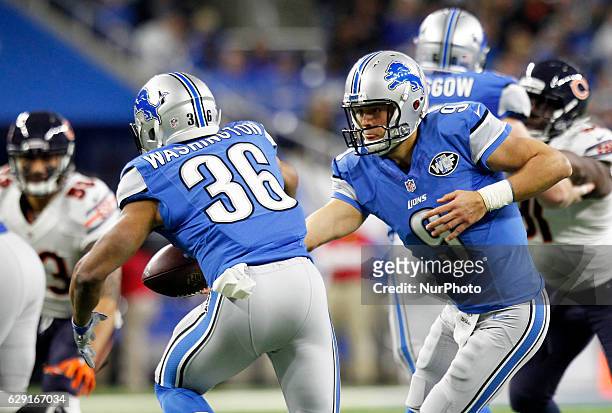 Detroit Lions quarterback Matthew Stafford hands the ball off to running back Dwayne Washington during the first half of an NFL football game against...