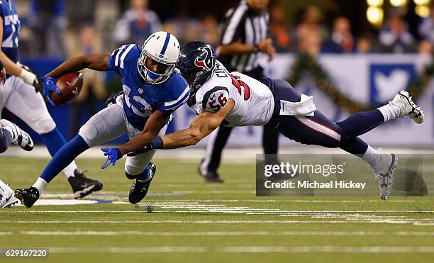 Hilton of the Indianapolis Colts runs the ball after a catch as Brian Cushing of the Houston Texans attempts the tackle at Lucas Oil Stadium on...