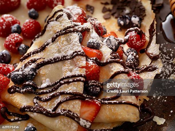 crepes with fresh berries, chocolate sauce and powdered sugar - french food stock pictures, royalty-free photos & images