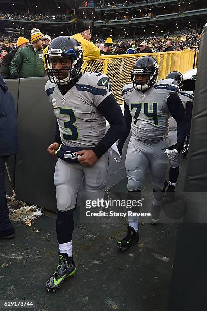Russell Wilson and George Fant of the Seattle Seahawks take the field prior to a game against the Green Bay Packers at Lambeau Field on December 11,...
