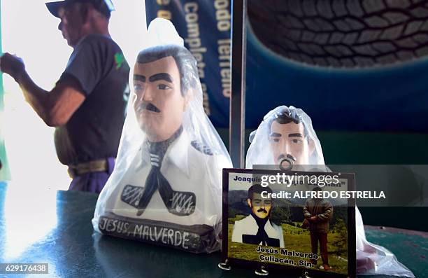 View of a picture depicting Mexican drug lord Joaquin Guzman aka "El Chapo" and narco-saint Jesus Malverde, who according to legend was a Robin...