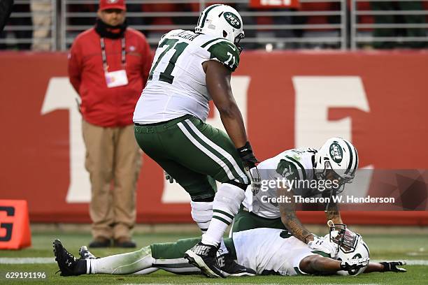 Bilal Powell of the New York Jets celebrates with teammates after scoring the game winning touchdown in overtime to beat the San Francisco 49ers...