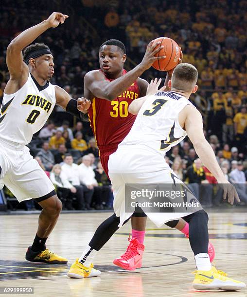 Guard Deonte Burton of the Iowa State Cyclones goes to the basket during the first half against forward Ahmad Wagner and guard Jordan Bohannon of the...