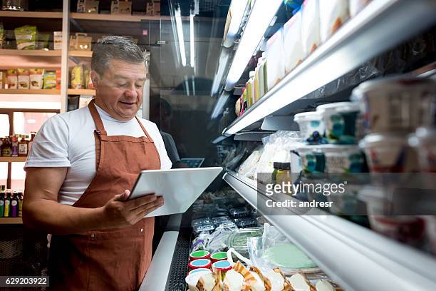 hombre que trabaja en una tienda de comestibles - food company manager fotografías e imágenes de stock