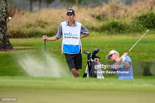 Jim Knous hits out of a greenside bunker on the 17th hole on the Crooked Cat Course as his caddie looks on during the final round of Web.com Tour...