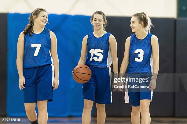 three female teenage basketball players walking together - african american girl wearing a white shirt stock pictures, royalty-free photos & images