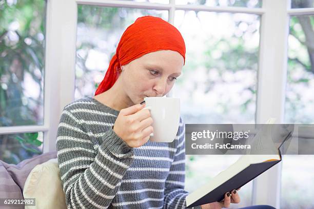 female cancer patient drinking tea and reading a book - guitar & medical books stock pictures, royalty-free photos & images