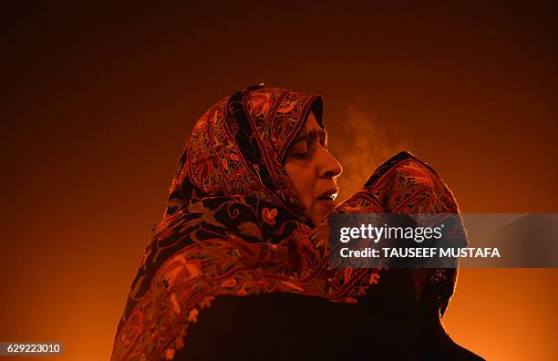 Kashmiri Muslim woman prays as a priest displays a relic believed to be a hair from the beard of Prophet Muhammed during Eid-e-Milad-un-Nabi, the...