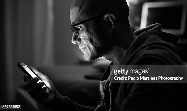 man using smart phone at home at night - black and white smartphone stock pictures, royalty-free photos & images