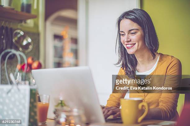 junge frau zu hause - woman portrait kitchen laptop stock-fotos und bilder