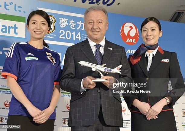 Japan - Japan's national soccer team coach Alberto Zaccheroni poses with a miniature model of a Japan Airlines aircraft painted with the Samurai Blue...