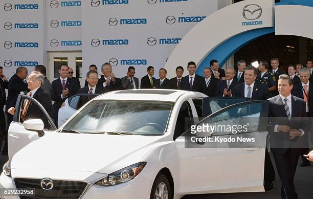 Mexico - Takashi Yamanouchi , chairman of Mazda Motor Corp., and Mexican President Enrique Pena Nieto emerge from the Mazda3 compact car to attend a...