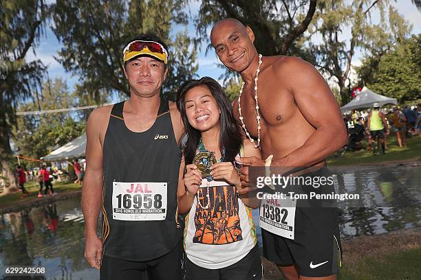Participants pose with finisher's medal during the Honolulu Marathon 2016 on December 11, 2016 in Honolulu, Hawaii.