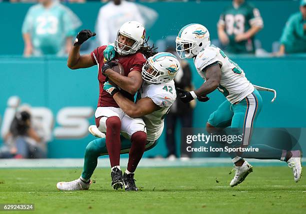 Dolphins linebacker Spencer Paysinger tackles Cardinals wide receiver Larry Fitzgerald during an NFL football game between the Arizona Cardinals and...