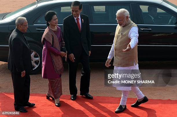 Indian Prime Minister Narendra Modi gestures to Indonesian President Joko Widodo and his wife HJ Iriana as Indian President Pranab Mukherjee looks on...