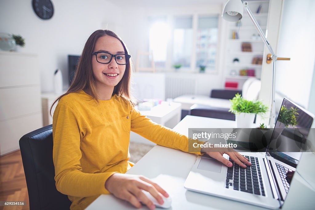 Girl doing homework on laptop