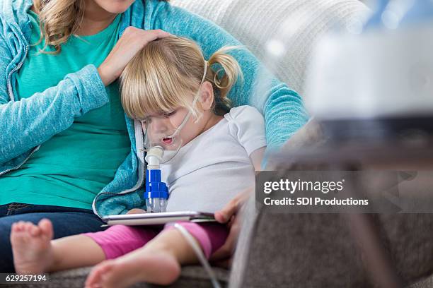 mom comforts daughter receiving breathing treatment - cystic fibrosis 個照片及圖片檔