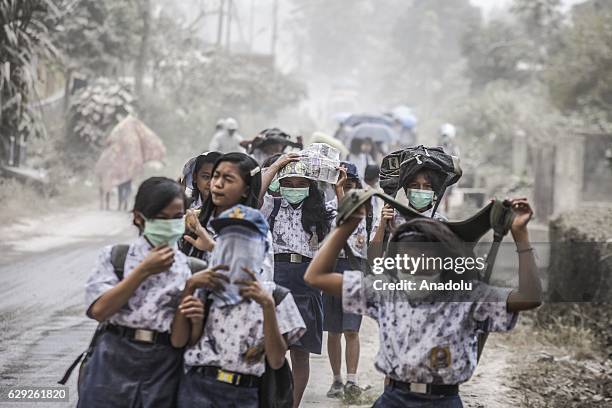 Residents use mask during an eruption in Mount Sinabung at Temberun village in Karo, North Sumatra, Indonesia on February 24, 2016. More than 10.000...