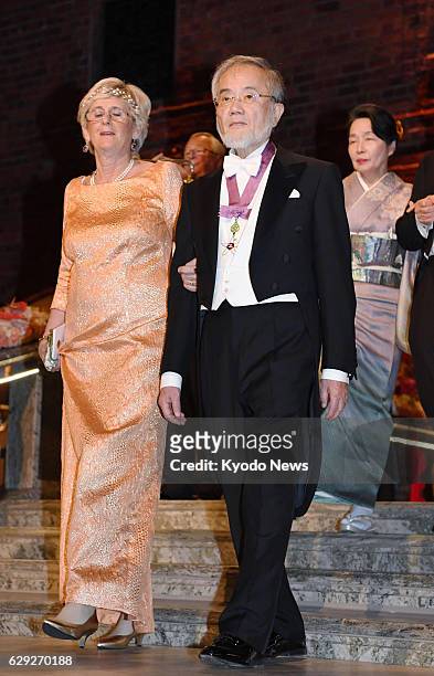 Nobel laureate Yoshinori Ohsumi arrives at the venue for a banquet in Stockholm on Dec. 10 with his wife Mariko seen behind him. Ohsumi was awarded...