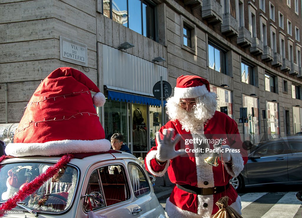 Santa Claus arrives on board of an old car Fiat 500 white...