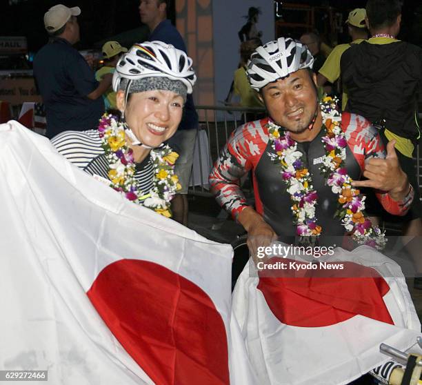 Wakako Tsuchida and Masazumi Soejima of Japan pose for photos with their country's flags after winning the women's and men's wheelchair divisions of...