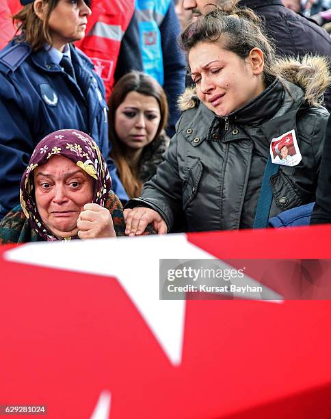 Relatives of police officer Erdem Ozcelik who was killed in bomb attacks outside the Vodafone Stadium in Besiktas on December 10 mourn over his...