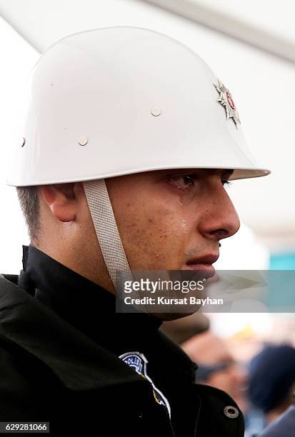 Turkish police cries during the funeral of police officer Erdem Ozcelik who was killed in bomb attacks outside the Vodafone Stadium in Besiktas on...