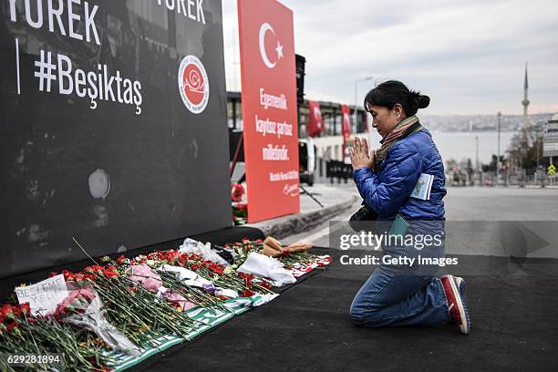 Woman prays at the blast site outside the Besiktas FC's Vodafone Arena Stadium in Istanbul, December 12 Turkey. At least 44 people were killed and...