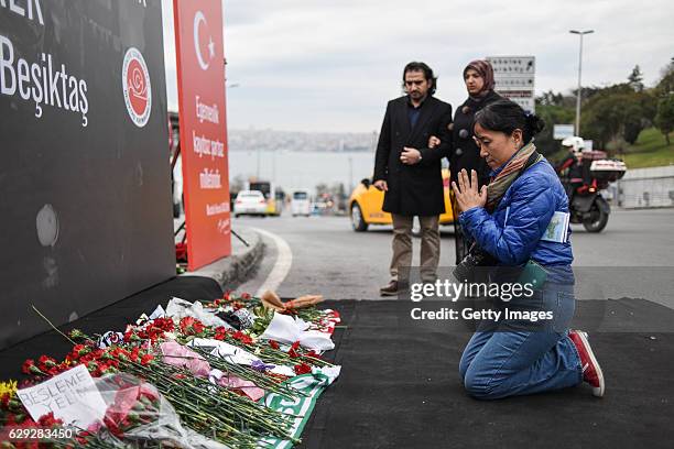 Woman prays at the blast site outside the Besiktas FC's Vodafone Arena Stadium in Istanbul, December 12 Turkey. At least 44 people were killed and...