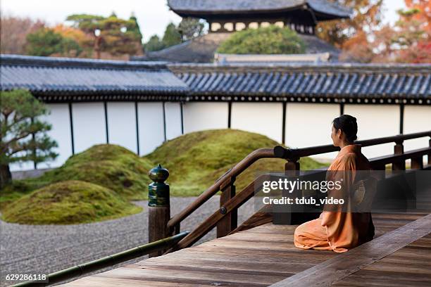 frau in kimono kniet in einem japanischen tempel - shintoismus stock-fotos und bilder