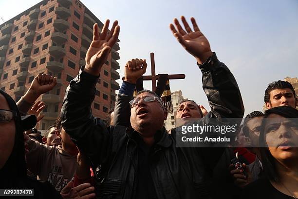People react during the funeral ceremony for the victims of the explosion at Saint Peter and Saint Paul Coptic Orthodox Church in Abbasiya district,...