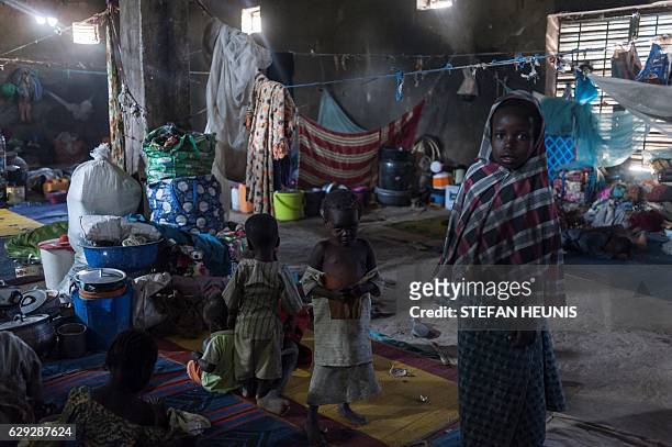 Children take refuge from the sun inside a warehouse made available for internally displaced people in one of the hosting communities in Maiduguri in...