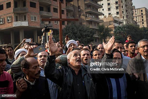 Christians protest outside the orthodox church of the Virgin Mary during the official funerals for victims of yesterdays St Peter and St Paul Church...