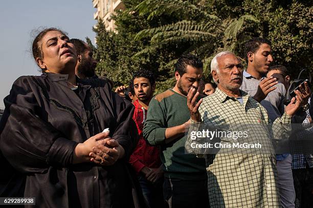 Christians pray in the street outside the orthodox church of the Virgin Mary during the official funerals for victims of yesterdays St Peter and St...