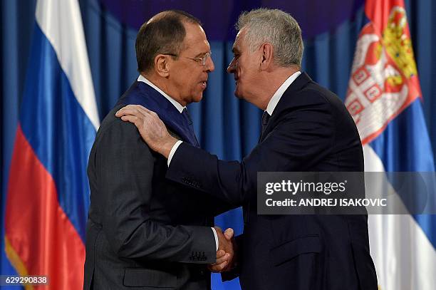 Russian Foreign Minister Sergei Lavrov shakes hands with Serbian President Tomislav Nikolic prior to their meeting in Belgrade on December 12, 2016....