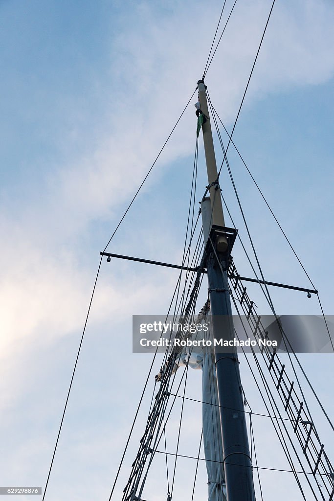 Ant view of a sail boat mast and closed sails against a...